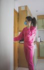 Молодая женщина в медицинской маске на дому — стоковое фото