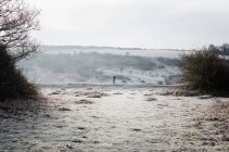 Woman walking along a frosty path in the English countryside in winter — Stock Photo