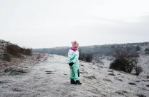 Jeune fille debout sur le sommet d'une colline dans la campagne anglaise — Photo de stock