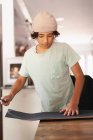 Middle Schooler boy applying grip tape to his skateboard. — Stock Photo