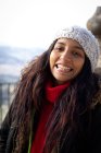 Красивая молодая женщина улыбается с пирсингом в парке в зимней шляпе — стоковое фото