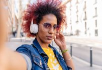 Selfie einer Frau mit Afro-Haaren mit Kopfhörern — Stockfoto