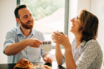 Paar lächelt und lacht glücklich beim Frühstück — Stockfoto