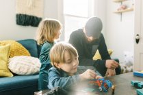 Смекалистый мальчик играет со строительными игрушками в семейной комнате — стоковое фото