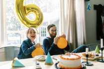 Father and son laughing together while playing with birthday balloons — Stock Photo