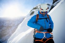 Männlicher Eiskletterer bereitet sich in letzter Minute auf den Aufstieg vor — Stockfoto