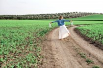 Молода дівчина в сукні позує в полі — стокове фото