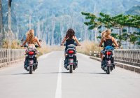 Tre amiche che cavalcano scooter in autostrada in Laos — Foto stock