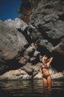 Abbronzatura bionda donna in bikini bancarelle nel fiume in un giorno d'estate — Foto stock