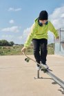 Молодий, підліток, зі скейтбордом, стрибає, на доріжці, скейтбординг, в навушниках — стокове фото