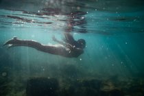 Chica buceo bajo el agua en el mar - foto de stock