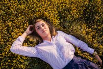 Молодая женщина в поле с цветами позирует — стоковое фото
