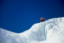 Guida di arrampicata su ghiaccio maschile che conduce una scalata su ghiaccio nel New Hampshire — Foto stock
