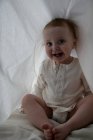 Bebê menina escondido sob o lençol — Fotografia de Stock