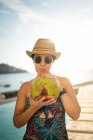Mulher feliz relaxar na piscina e beber água de coco — Fotografia de Stock