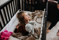 Schöne junge Tochter im Bett mit Spielzeug — Stockfoto