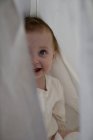 Bambina nascosto dietro lenzuolo — Foto stock