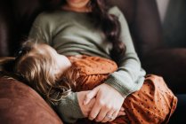Beautiful young mother and her daughter on armchair — Stock Photo