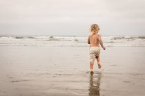 Lindo niño en la playa relajante - foto de stock