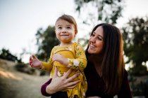 Young woman with daughter in the park — Stock Photo