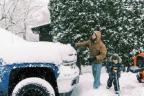 Батько з сином розчищають сніг на дорозі в Массачусетсі. — стокове фото
