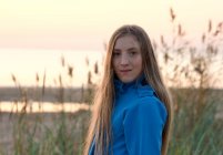 Portrait de jeune adolescente en veste à capuche à la plage — Photo de stock