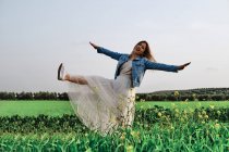 Junges Mädchen in einem Kleid posiert auf einem Feld — Stockfoto