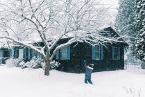 Little girl playing in snow during a nor'easter storm in front yard — Stock Photo