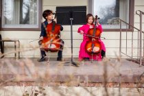 Dos niños dando concierto de violonchelo - foto de stock