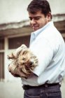 Mann mit süßem, ungepflegtem Hundewelpen schaut in Kamera — Stockfoto