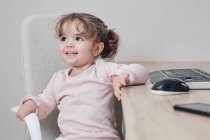 Двухлетняя девочка пользуется компьютерной клавиатурой — стоковое фото