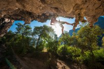 Mann klettert auf überhängende Kalksteinklippe in Laos — Stockfoto