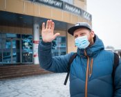 Uomo che indossa maschere anti virus salutando i suoi amici — Foto stock