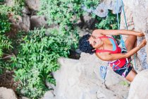 Mujer escalando escarpado acantilado de piedra caliza en Laos - foto de stock