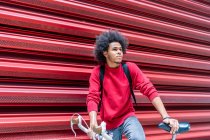 Jeune homme aux cheveux afro avec son vélo — Photo de stock