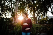 Pregnant woman  posing in the park — Stock Photo