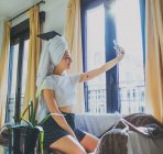 Счастливая улыбающаяся молодая женщина в спальне отеля — стоковое фото