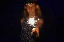 Mädchen hält eine helle Wunderkerze in der Hand — Stockfoto