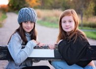 Duas jovens tween meninas em suéteres ao ar livre na estrada do país. — Fotografia de Stock