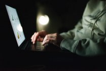 Анонимная женщина, работающая ночью на ноутбуке — стоковое фото