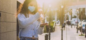 Молода жінка наносить гель для дезінфекції на руки на вулиці — стокове фото