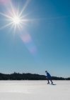 Adolescente patinando en un lago congelado en Canadá en un día soleado de invierno. - foto de stock