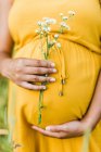 Gros plan de attendre mère noire tenant son ventre enceinte avec amour — Photo de stock