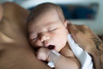Un recién nacido con su joven madre en el hospital descansando. - foto de stock