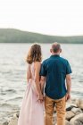 Couple sharing a tender moment by the water during sunset together — Stock Photo