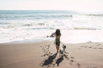 Donna che scatta foto sulla spiaggia, con il suo cane. Concetto di fotografo. — Foto stock