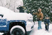 Vater und Sohn räumen gemeinsam Schnee in Einfahrt in Massachusetts — Stockfoto