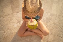 Mulher feliz relaxar na piscina e beber água de coco. — Fotografia de Stock