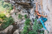 Mulher escalando penhasco íngreme calcário no Laos — Fotografia de Stock