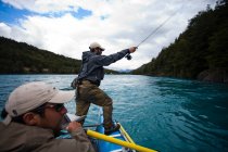 Dos pescadores flotan por el Río Baker en el sur de Chile en una región llamada Patagonia. - foto de stock